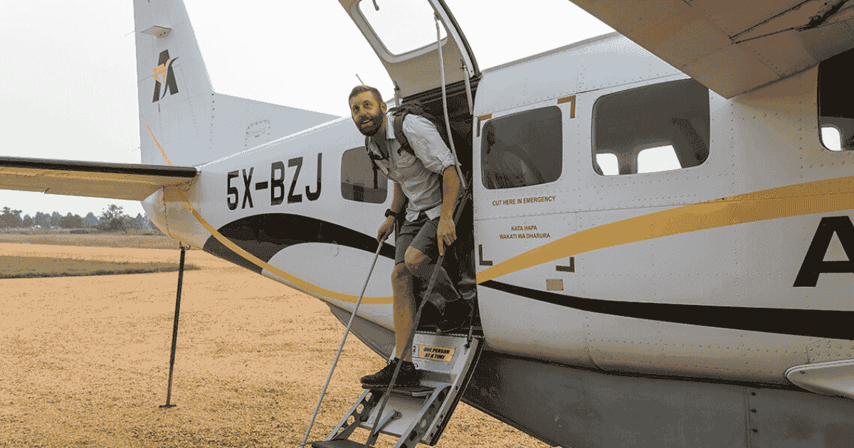 eric hanson getting off a cessna plane in uganda on a backpacking and hiking trip